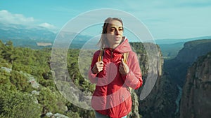 View point Tazy Canyon. girl standing and admiring stunning scenery in mountains. Tourist woman hiker in red jacket on