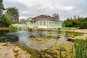 View of pond and wooden house museum of the 19th century in Dmitrov. Russia