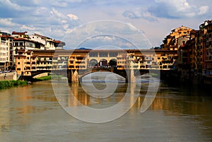 View of the Ponte Vecchio arch bridge with houses across the Arno river in Florence, Italy