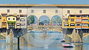 View on The Ponte Vecchio on a sunny day timelapse, a medieval stone segmental arch bridge over the Arno River, in