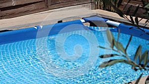 View of a pool with the water filtering pump working on a sunny and windy day