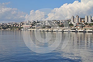 View of the port in Croatia, the city of Rijeka, blocks by the sea, high blocks, built-up coast, white thick clouds, cranes in the