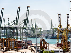 View of the Port of Singapore cargo terminal at Tanjong Pagar. Container cranes and shipping containers are clearly visible next photo