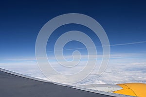 View from the porthole of an airplane flying above the clouds