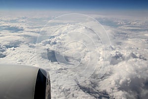 View from the porthole of the airplane to the blue sky with white clouds