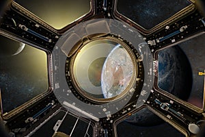 View from a porthole of space station on the Earth background.