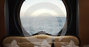 View through a porthole on a stormy sea with waves on cruise ship in restorante.