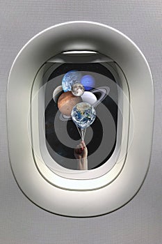 View from porthole window on hand with planets shaped balloons in solar system. Elements of this image furnished by NASA