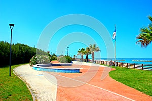 View in Porto Potenza Picena at a seawalk with meadows, flowers, palm trees, places to sit and flags