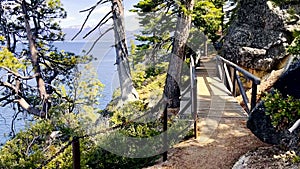 View, POV walking down mountain stone path by lake Tahoe in California. Walking tourist route near the lake in the