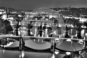 View on the Prague cityscape together with the bridges crossing the vltava river passing through the city, all in black and white