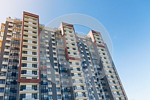 View of public park with newly built modern block of flats under blue sky with few clouds