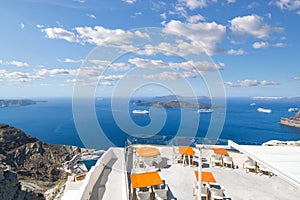 View from a public viewing area above a terrace of the cruise port, caldera, ships and outer islands of Santorini, Greece