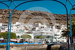 View of Puerto de Mogan traditional spanish village in Gran canaria island with old white houses and mountains in backgroumd on a