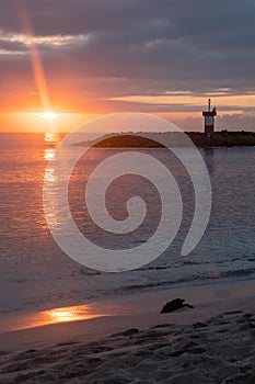 View of the Punta Carola Lighthouse and the beach during a reddish sunset, San Cristobal Island, Galapagos Islands.