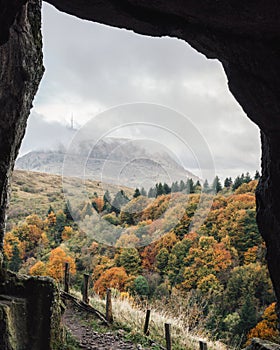 View of Puy de Dome from Clierzou caves in Auvergne, France, under autumn clouds.