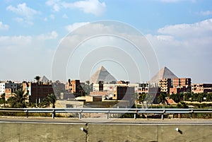 View of the pyramids of Keops, Kefren and Menkaure from the ring road of Cairo. Ahead half-built homes photo