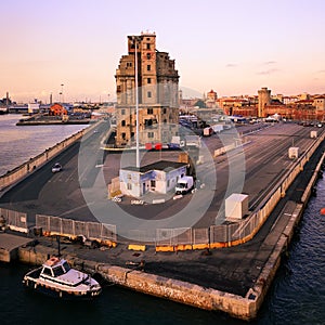 View of a quay of the port of Livorno at sunset. Old abandoned building. Industrial archeology