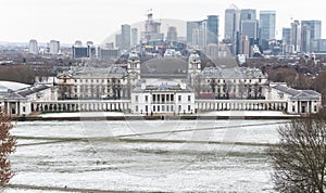 View of Queens House and Canary Wharf from Greenwich Park in winter snow