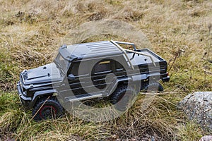 View of radio controlled model Mercedes Benz racing car on off-road background.