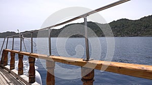 View through railing of cruise ship on misty but sunny day at sea. Turkish coast near the island of Kekova