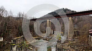 View of the railway bridge over the Prut river. A small town or village of Yaremche among the Carpathians on an autumn afternoon