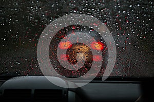 View from a rain-drenched windshield on a car in front.