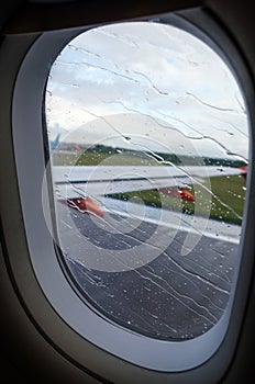 View of rainy airplane window during takeoff