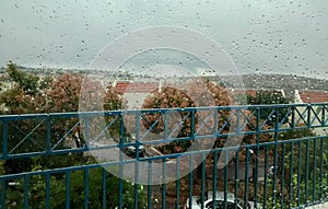 View through rainy porch door of street below