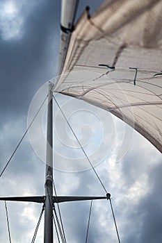 View of the raised sail from the deck up to the sky.