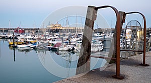 View of Ramsgate Royal Harbour taken in the early evening light, with the masts of the yachts reflected in the water.