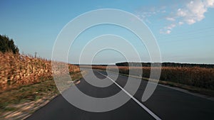 View through rear windshield windscreen of car in motion, back glass screen. Single carriageway with two-lane road along