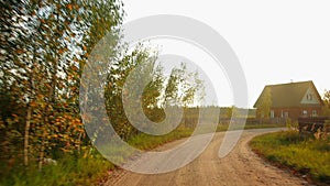 View through rear windshield windscreen of car in motion, back glass screen. Turn of the sandy dirt road in the village