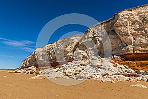 A view of a recent rock fall of white chalk that obscures the stratified layers on the cliffs of Old Hunstanton, Norfolk, UK