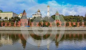 View of the red Kremlin wall, tower and golden onion domes of cathedrals over the Moskva River in Moscow, Russia