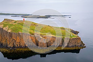 view of the red lighthouse on the cliff in the harbour of Stykkisholmur