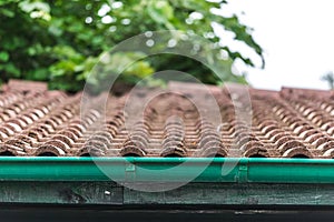 View of red roof tiles and sky and tree on the background