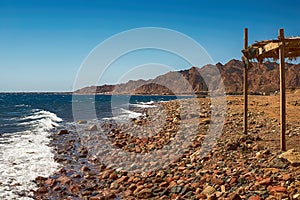 View of the Red Sea shore, pebble beach and kami close-up. Leisure concentration. Egypt, Dahab