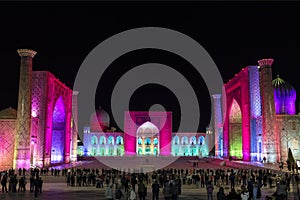 View of Registan square in Samarkand with Ulugbek madrassas, Sherdor madrassas and Tillya-Kari madrassas at night with pink backli