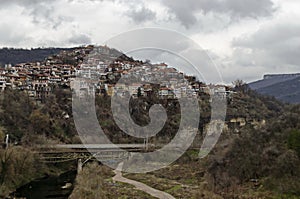 View of a residential neighborhood with old houses interestingly situated next to each other on  steep hill and bridge over Yantra