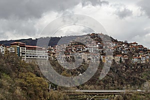 View of a residential neighborhood with old houses interestingly situated next to each other on  steep hill and bridge over Yantra