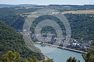 view into a Rhine valley with small town Oberwesel, red church and castle on the left