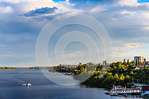 View of the right bank from the Voronezh reservoir. Water, lake, boat, dock, city with trees and houses