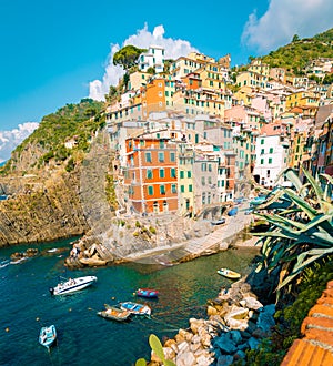 View of Riomaggiore one of Cinque Terre in the province of Riomaggiore, Italy, happy young couple picnic in the mountain