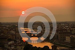 View of the River Arno and famous bridge Ponte Vecchio. Amazing evening golden hour light. Beautiful gold sunset in Florence.