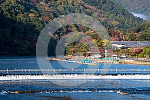 A view of the of the river and autumn colours of the surrounding mountains, seen from Togetsu-kyo bridge.