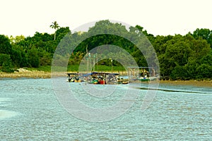 View of a river with a jetty and fishing boats in Pekan, Pahang, Malaysia