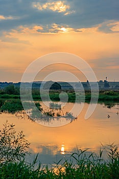 View of river surface on a background of dramatic sky at sunset on a summer evening. River landscape