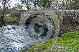 A view of  the River Syfynwy flowing under an eighteenth-century bridge at Gelli, Wales