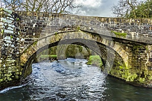 A view of the River Syfynwy flowing under the large arch of the Gelli bridge, Wales photo
